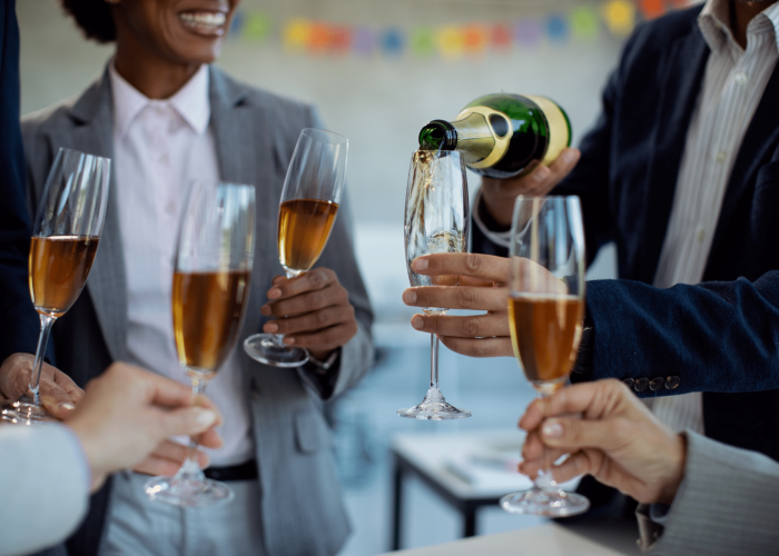 close-up-of-colleagues-pouring-champagne-while-cel-2026-04-13-02-17-43-utc
